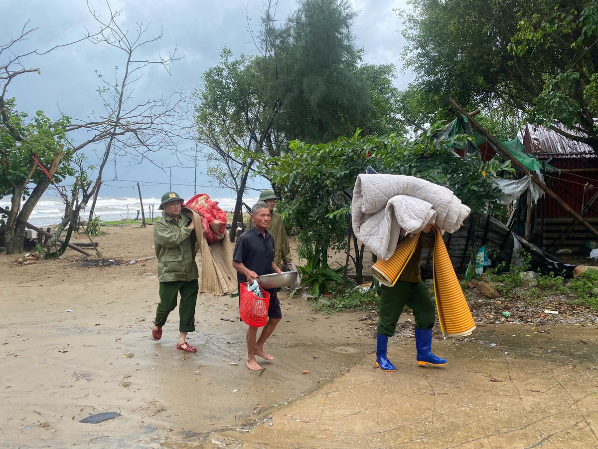 Trong ảnh là lực lượng Công an phường Ngọc Sơn hỗ trợ người dân khu vực ven biển mang đồ dùng, dụng cụ sinh hoạt di dời tới nơi tránh trú an toàn. Ảnh: CANS