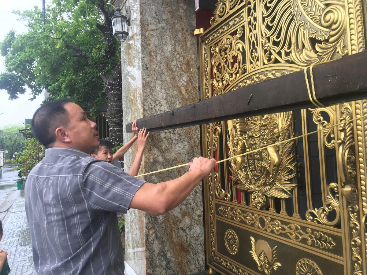 Nhận định bão số 10 (bão Bualoi) với gió mạnh tới cấp 10-12, có thể gây thiệt hại lớn, nhiều người dân tại Nghệ An tranh thủ gia cố nhà cửa, cắt tỉa, chằng chống cây cối trước giờ bão đổ bộ. Ảnh: Quốc Thanh.