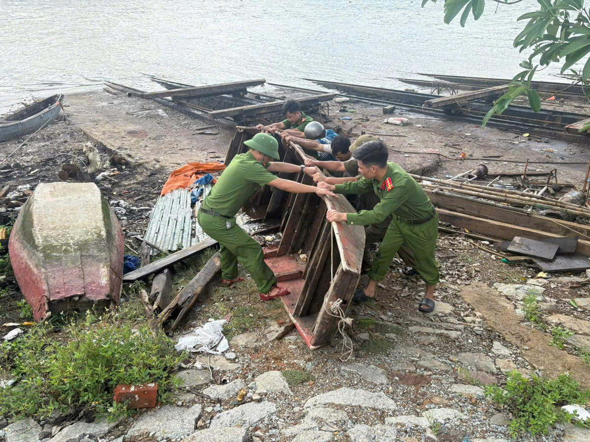 Lực lượng Công an ở Hà Tĩnh giúp dân di chuyển tàu thuyền đến nơi an toàn. Ảnh: CA.
