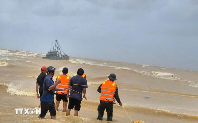  Cán bộ, chiến sỹ và nhân dân khẩn trương, tích cực cứu nạn hai tàu cá gặp nạn trên đường vào tránh trú bão số 10. (Ảnh: TTXVN phát).