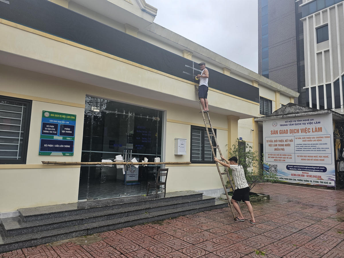 Cán bộ Trung tâm Dịch vụ Việc làm Nghệ An gia cố trụ sở làm việc trước giờ bão số 10 đổ bộ. Ảnh: Quốc Thanh.