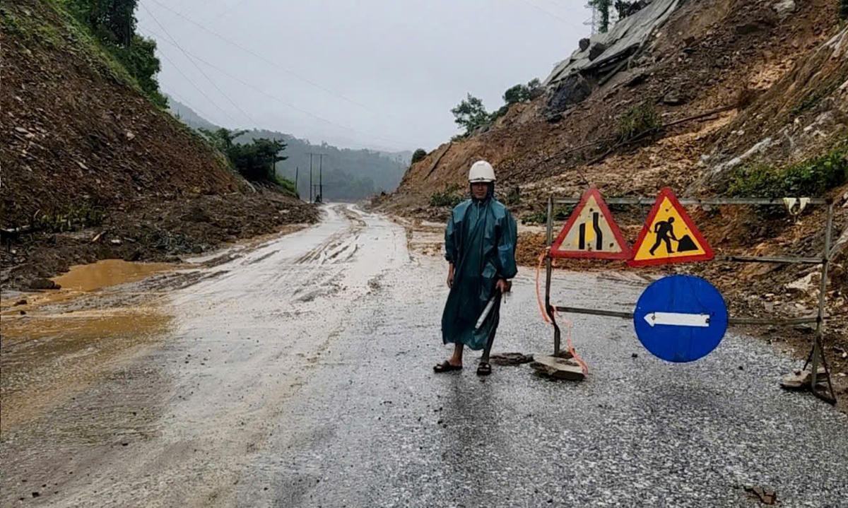 Tuyến quốc lộ 14E đoạn đi qua đồi núi đã phải có người hướng dẫn giao thông, lập biển báo. Ảnh: CV.