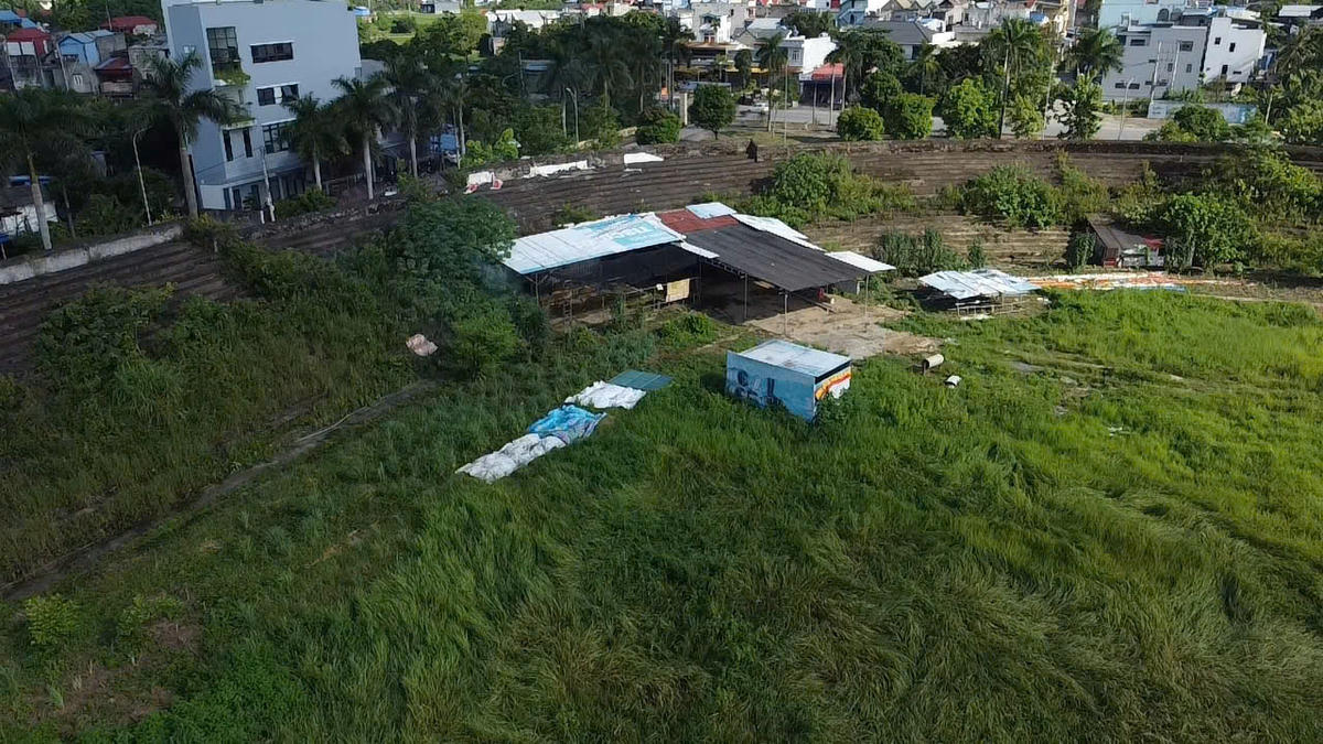 Góc phía nam của sân vận động, ngoài một lán tạm được dựng lên là cỏ dại bao quanh và lộ rõ cảnh tượng hoang tàn. Ảnh: Toán Nguyễn.