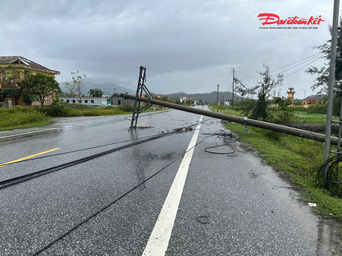 Cột điện đổ xuống, chắn ngang mặt đường, dây điện sà xuống mặt đất. 