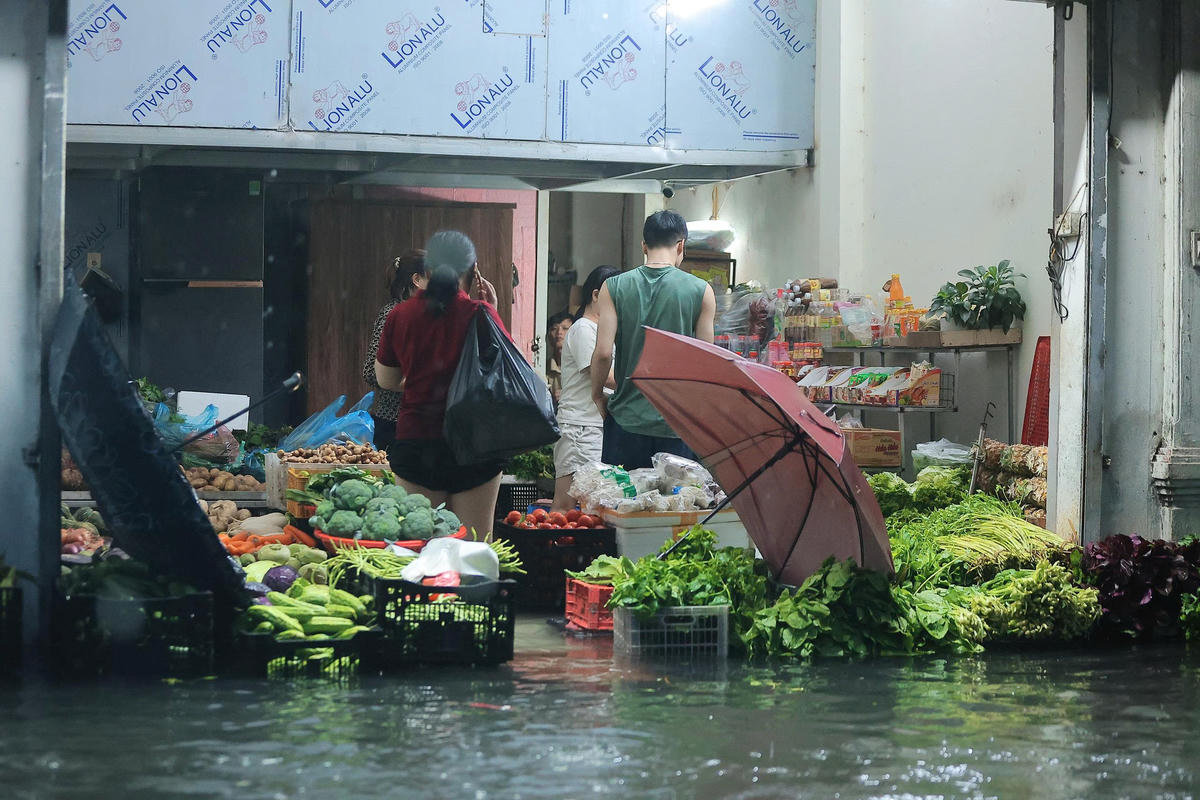 Nhiều sạp bán rau đã bắt đầu bị ngập nước.