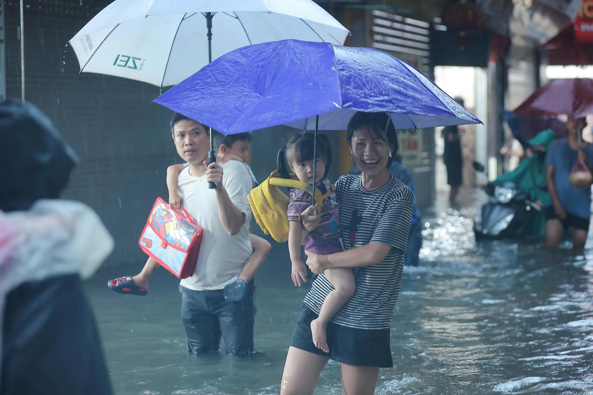 Theo ghi nhận của PV Báo Đại đoàn kết, khoảng 18h ngày 30/9, do mưa kéo dài, các tuyến đường xảy ra ngập úng, nhiều phụ huynh phải cõng con trở về nhà.