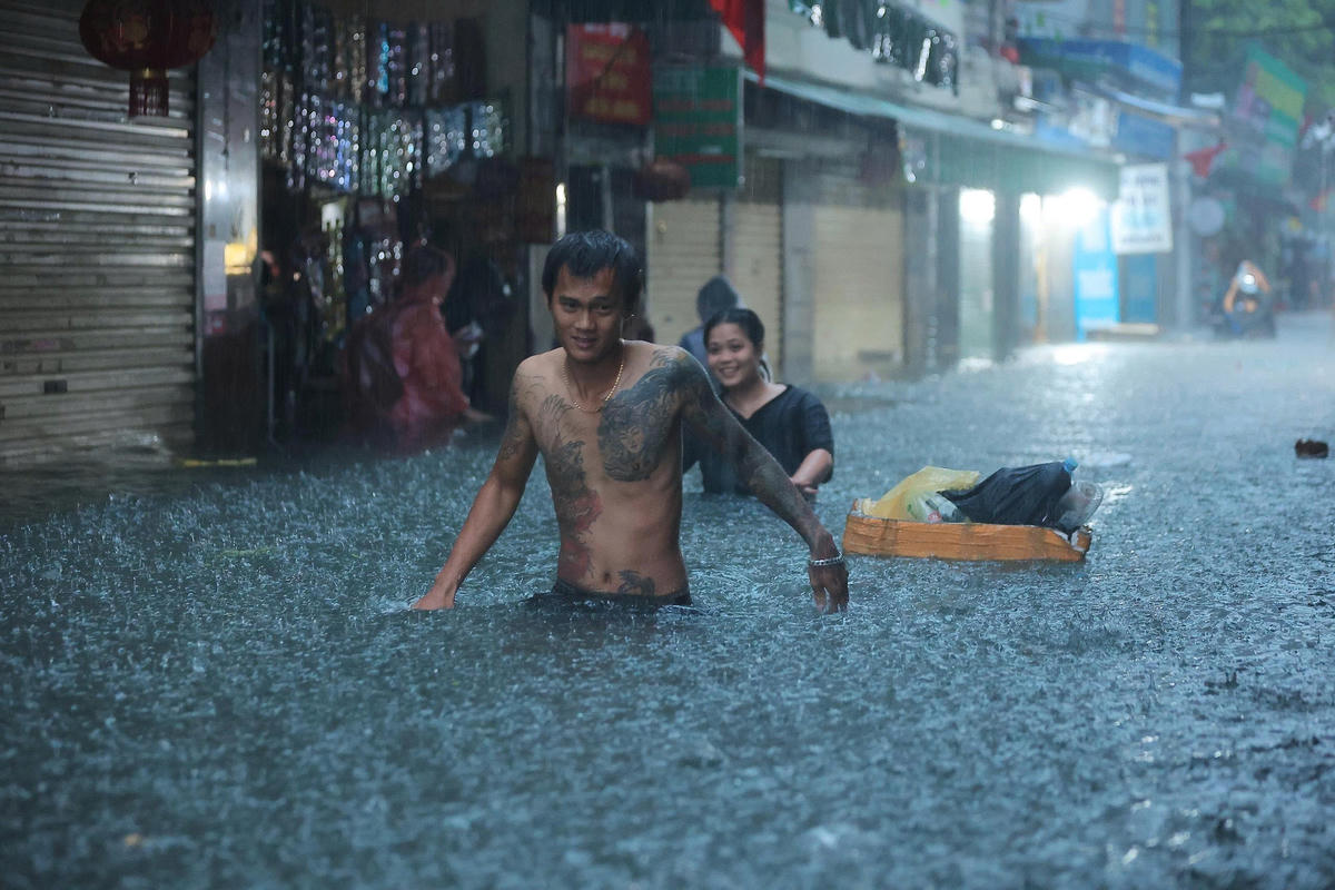 Nước ngập, người dân chỉ có thể di chuyển chậm để đảm bảo an toàn. 