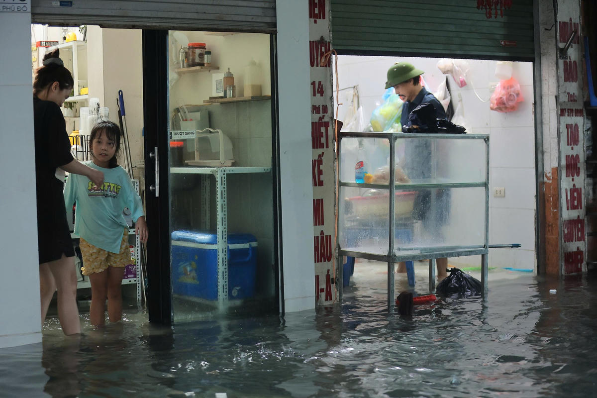 Đường ngập úng không thể đi xe: Người Hà Nội 'cõng con' về nhà