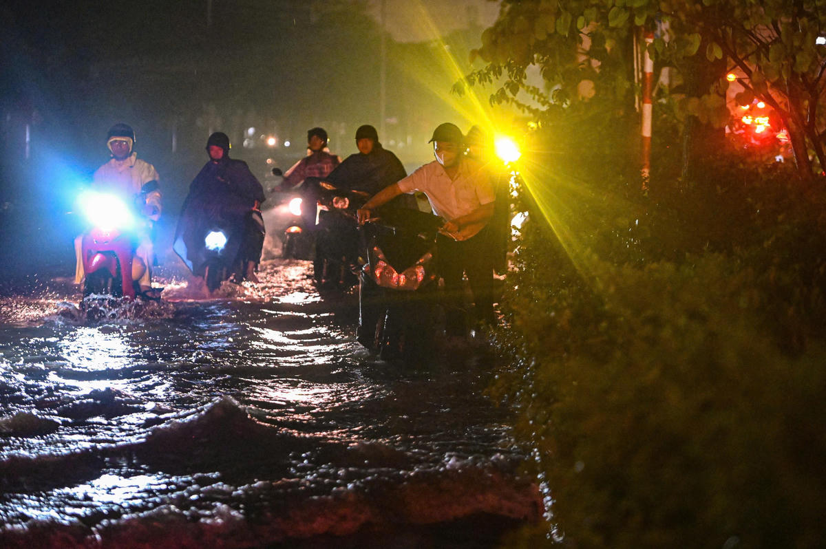 Xe chết máy, nhiều người vất vả dắt xe lội bì bõm qua vũng nước dài hàng trăm mét.