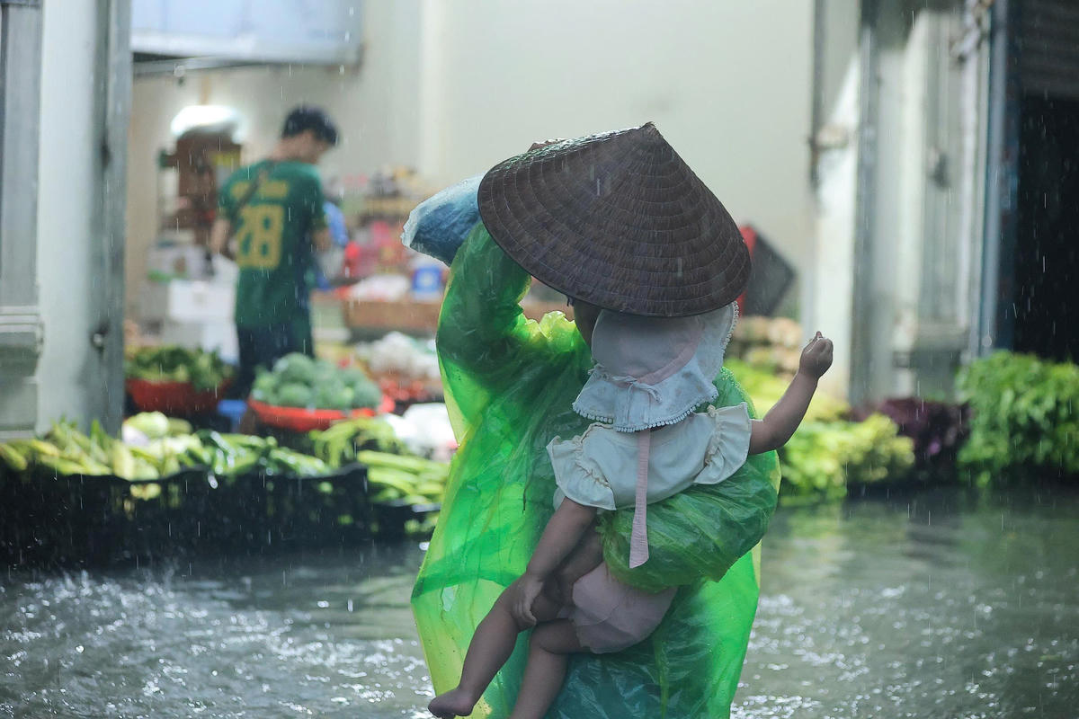 Đường ngập úng không thể đi xe: Người Hà Nội 'cõng con' về nhà