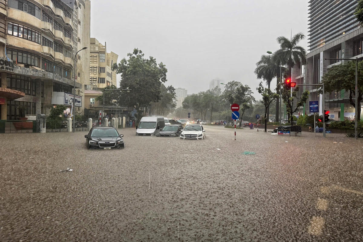 Theo ghi nhận của PV Báo Đại đoàn kết, mưa lớn gây ngập úng, tại tuyến đường Thái Hà - Láng Hạ xuất hiện hàng loạt ô tô 'chết máy' nằm 'la liệt'.
