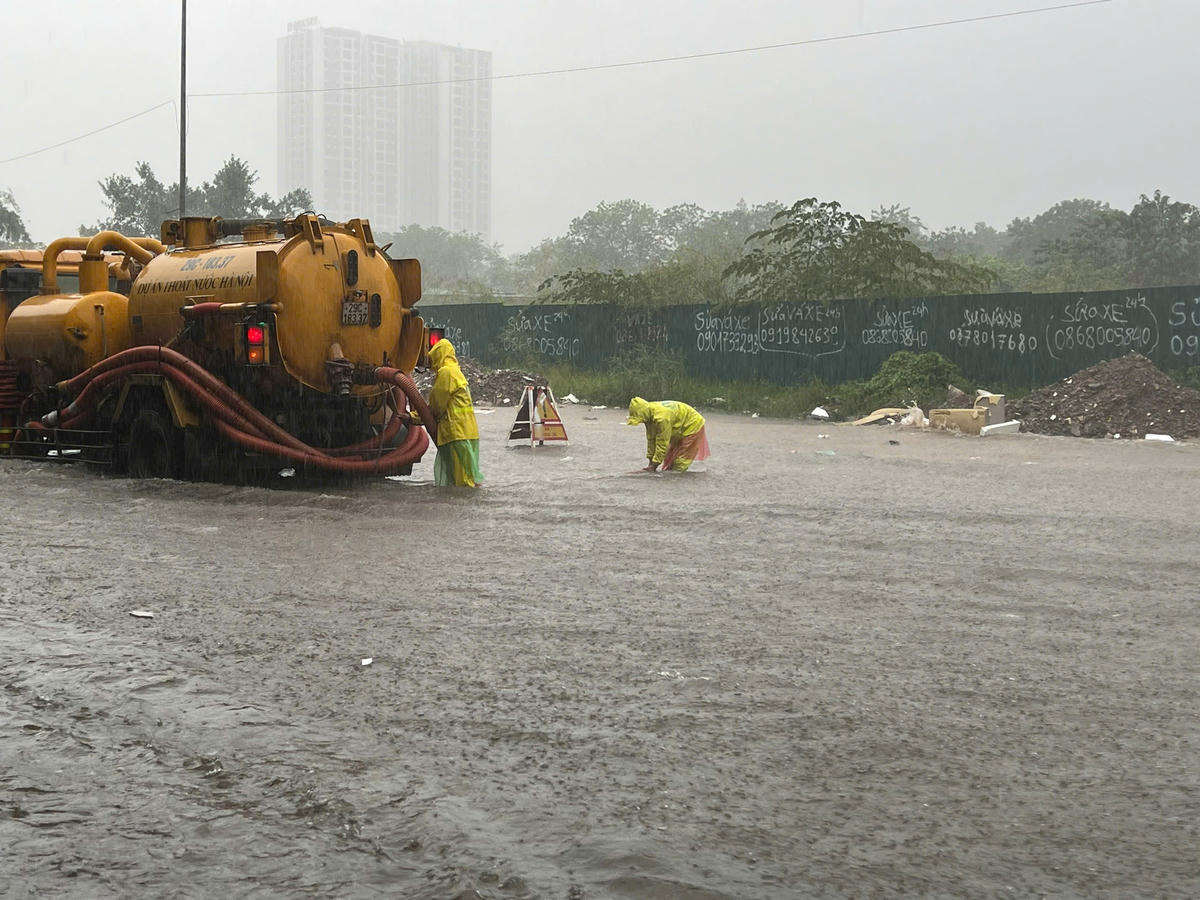 Nước ngập gần nửa người, công nhân thoát nước vẫn tất bật làm việc trên đường Nguyễn Xiển.
