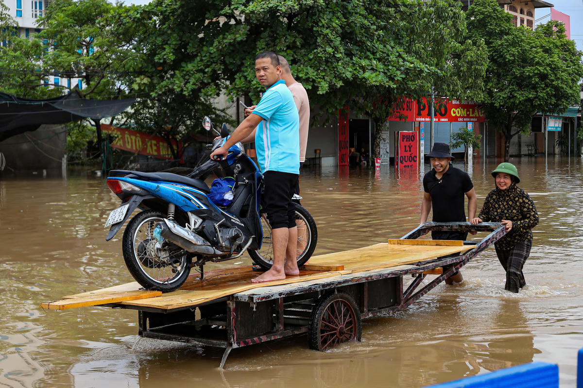 Từng chiếc xe máy liên tục được vận chuyển qua các vùng nước sâu.