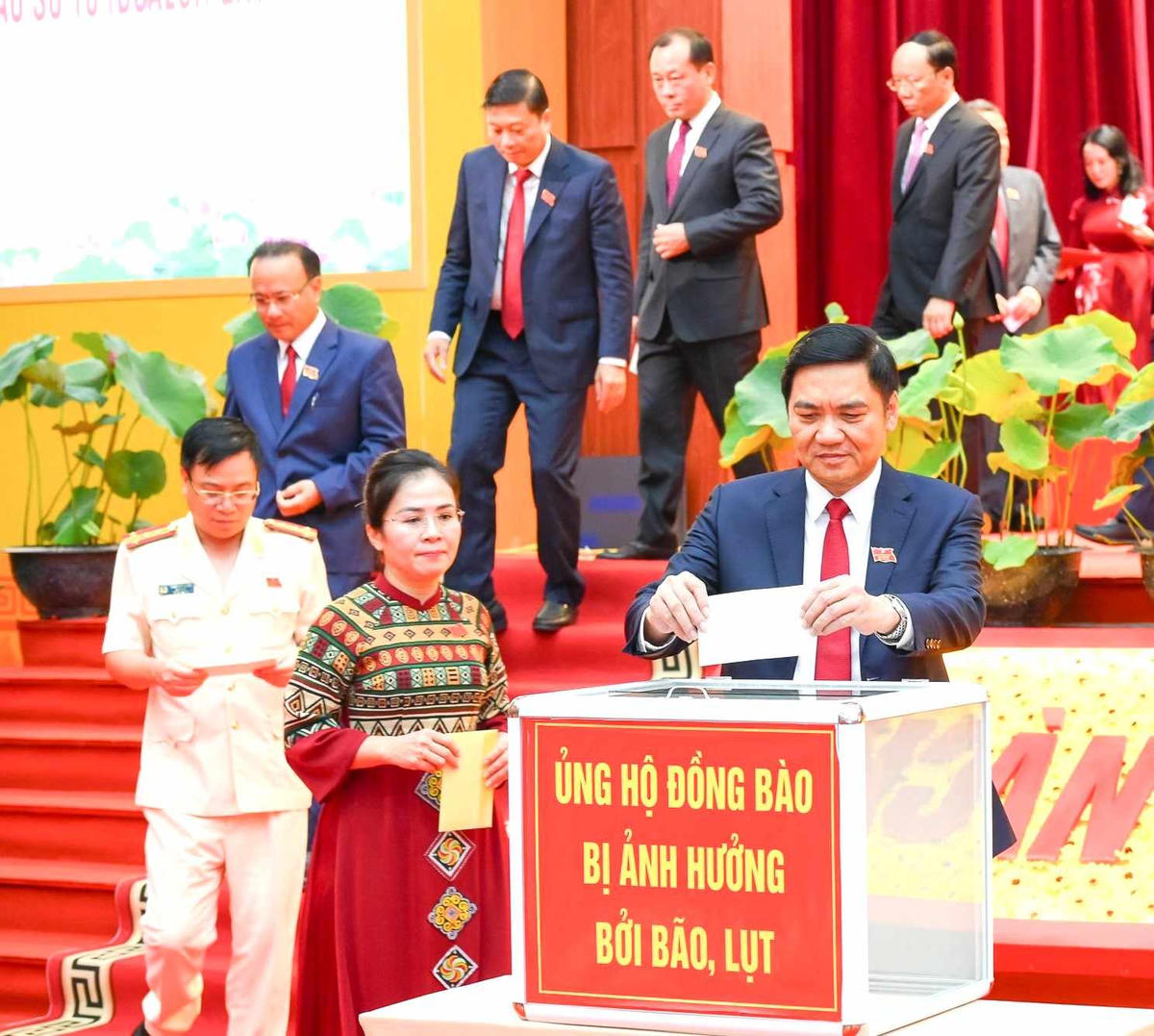 Các đại biểu chung tay ủng hộ người dân bị ảnh hưởng bão lũ. Ảnh: TC