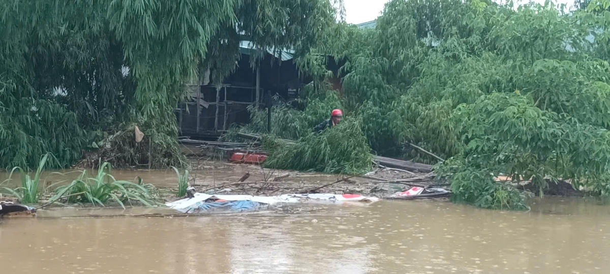 Người dân bám trên bè nổi đang tìm cách vào bờ. Ảnh: Xuân Trường.