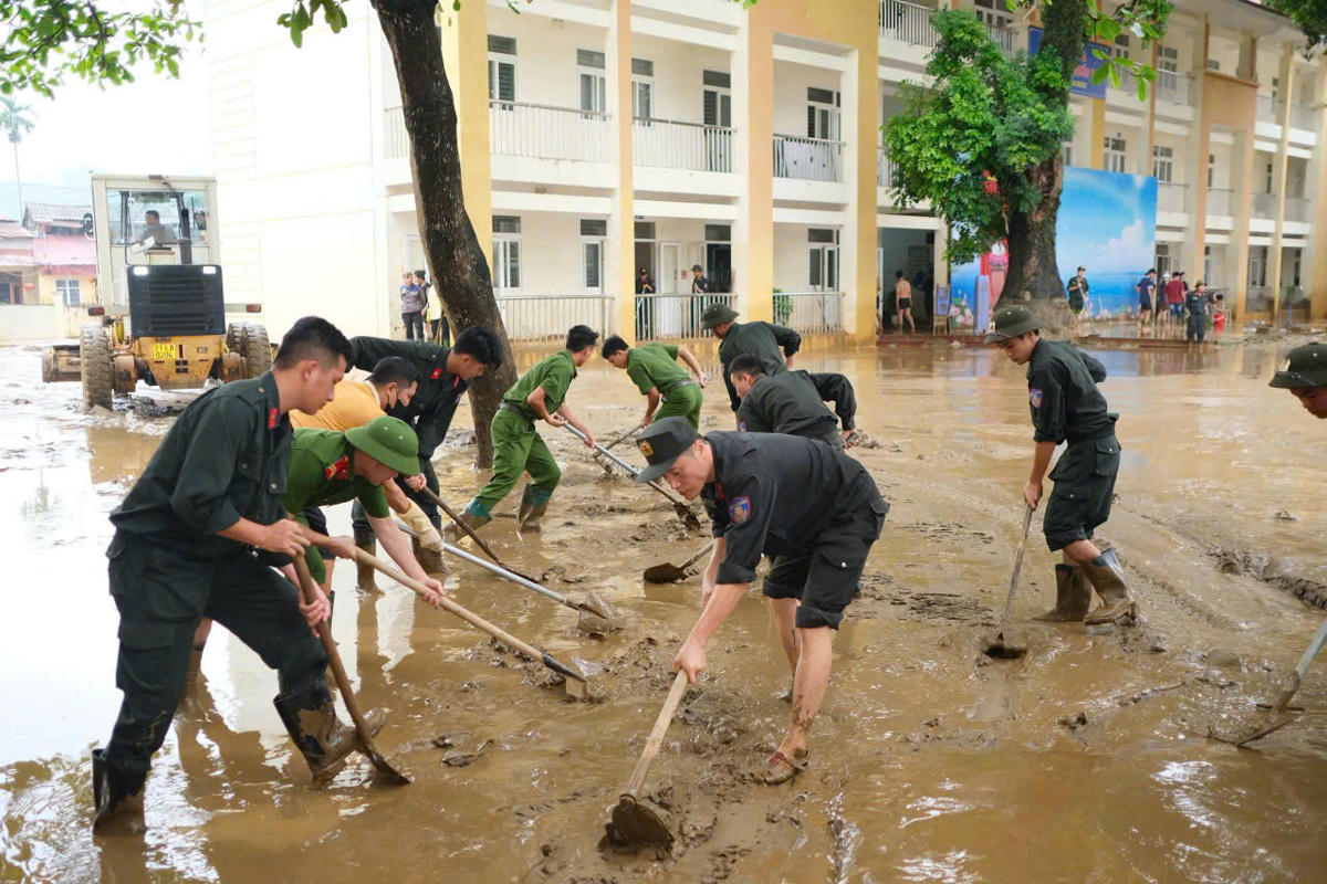 Lực lượng chức năng giúp đỡ người dân. Ảnh: Nguyễn Chung.