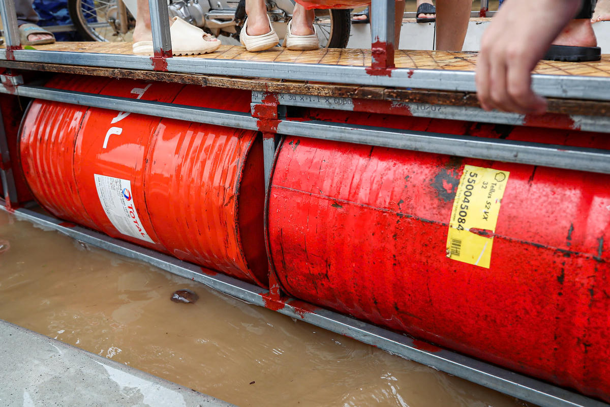 Chiếc phà tự chế được làm bằng các ống kẽm và những chiếc thùng phi.