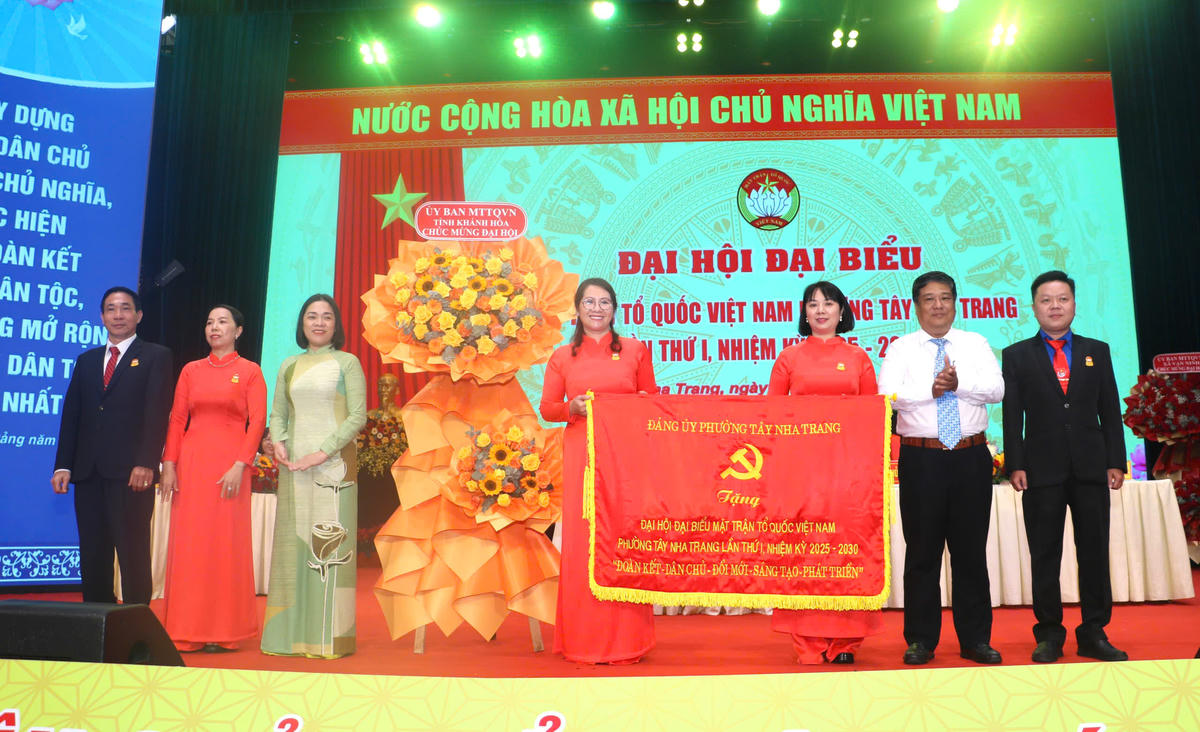 Bà Trần Thu Mai cùng lãnh đạo Đảng ủy phường
Tây Nha Trang tặng hoa và bức trướng chúc mừng Đại hội. (ảnh X.H)