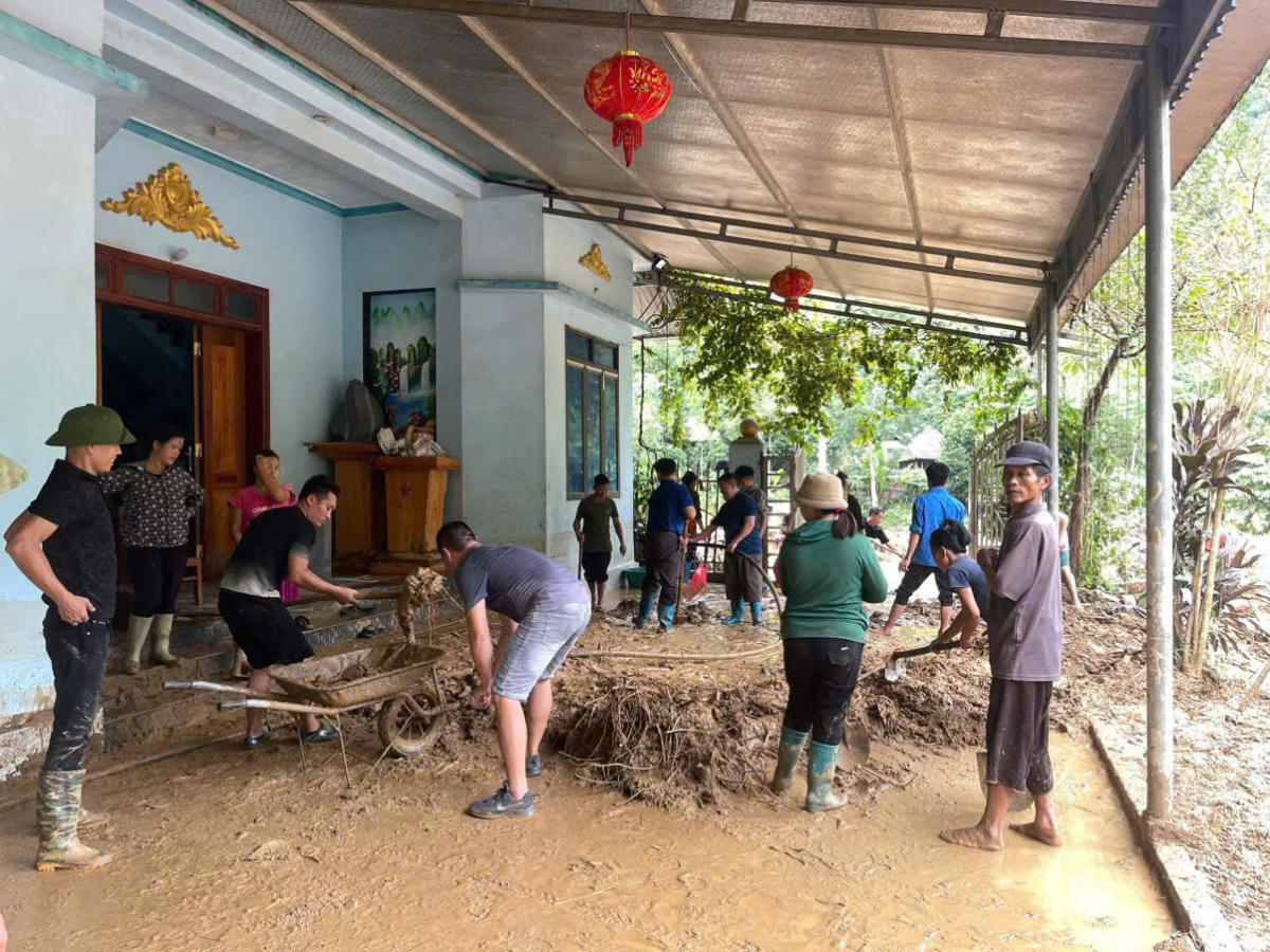 Lực lượng chức năng xã Mỏ Vàng, tỉnh Lào Cai giúp người dân dọn dẹp bùn đất để ổn định cuộc sống.