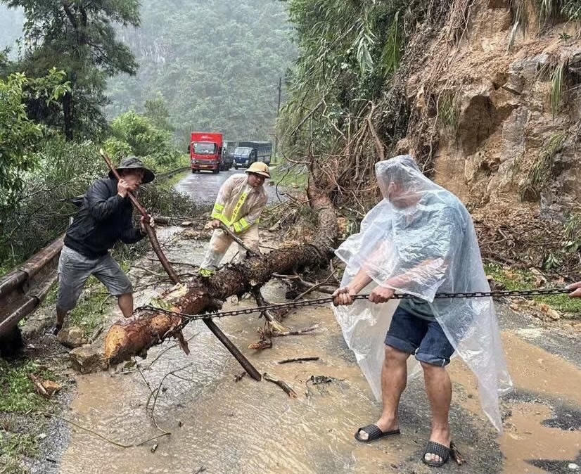 Lực lượng chức năng và người dân đang dọn dẹp đất đá, cây đổ hậu bão số 10. Ảnh: Tuấn Trung.