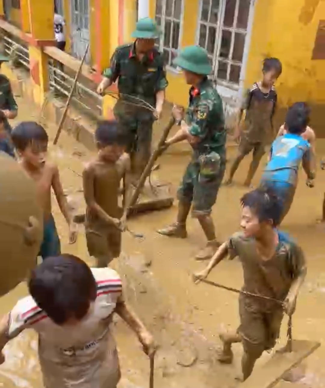 Người đầy bùn đất từ đầu đến chân, nhưng ánh mắt sáng, tinh anh, em Đặng Trung Hiếu, lớp 8C cho biết, lũ rút, chưa có lớp học, thấy các thầy cô và các chú bộ đội dọn trường, chúng em cũng tham gia cùng, đỡ được phần nào hay phần đó. Ảnh: Ngô Hùng.