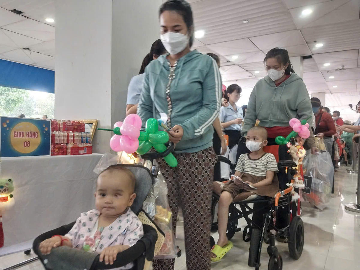 Bệnh nhi xếp hàng nhận quà tại các gian hàng ở Bệnh viện Ung bướu. Ảnh: S.X