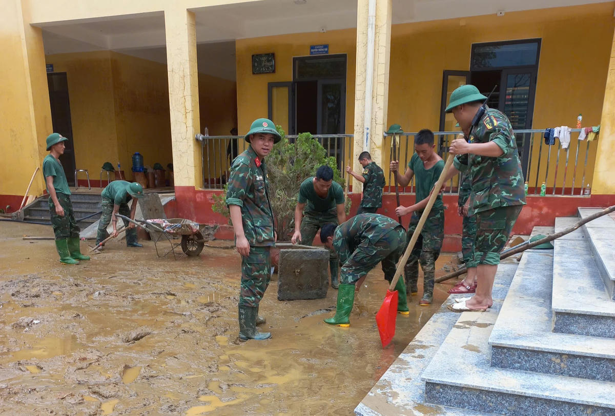 Khi nước rút hẳn, chính quyền địa phương, quân đội và các thầy cô giáo cùng nhau dọn dẹp lại trường. Ảnh: Ngô Hùng.