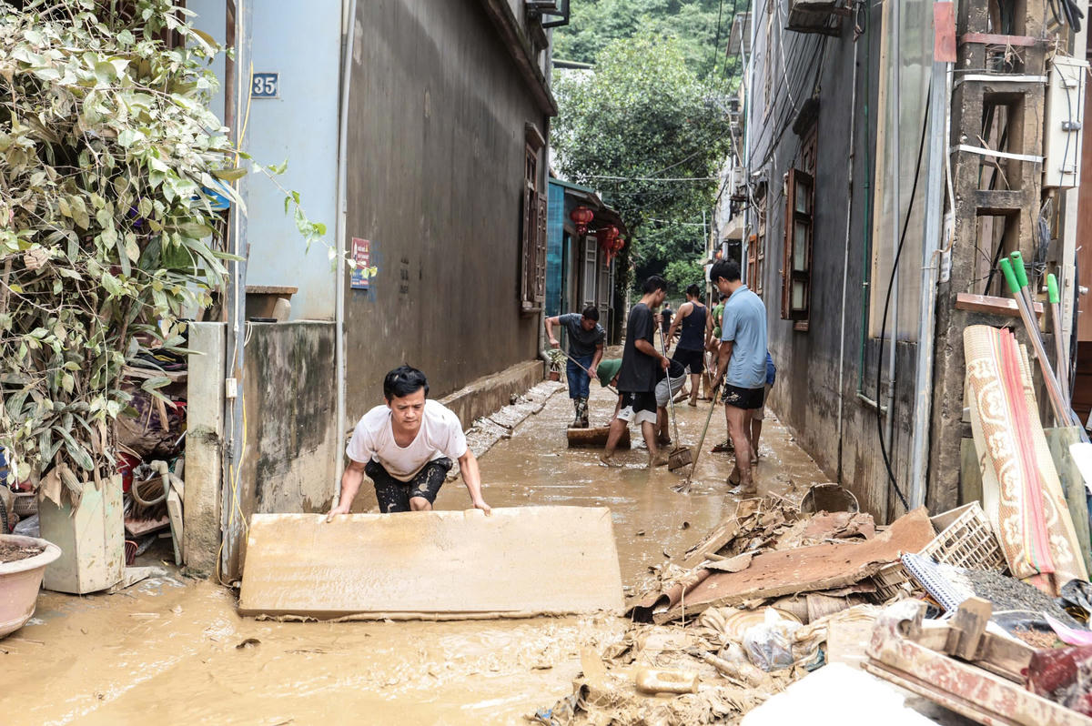 Người dân dọn dẹp bùn đất, nhà cửa, phố phường - gượng dậy sau lũ. Ảnh: Vũ Mừng.