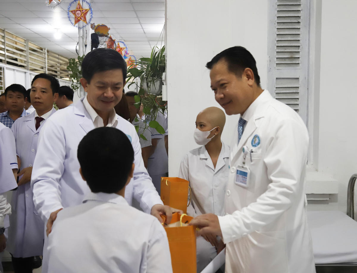 Bí thư Thành ủy Cần Thơ Lê Quang Tùng cùng Giám đốc Bệnh viện Ung bướu Cần Thơ Võ Văn Kha thăm hỏi động viên các trẻ em bị bệnh ung thư. Ảnh Trung Kiên. 