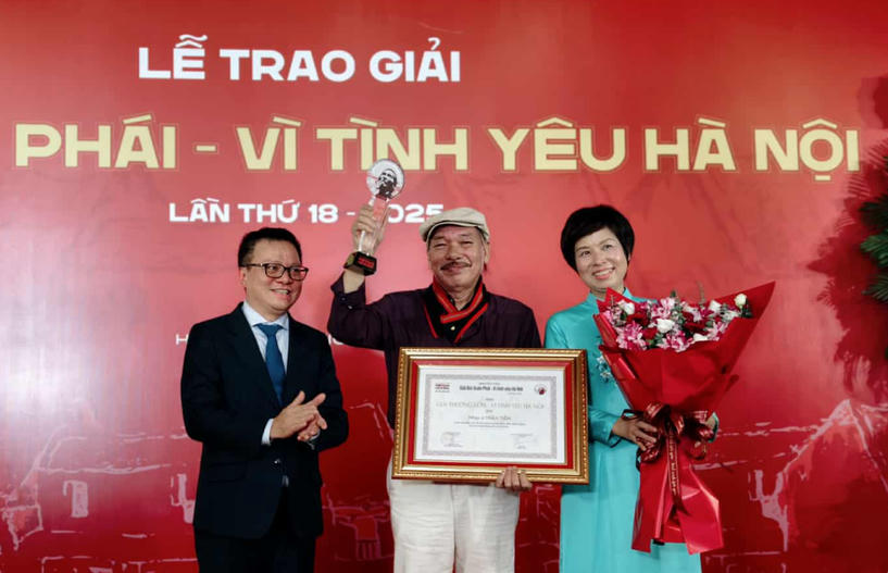 Ông Lê Quốc Minh, Ủy viên Trung ương Đảng, Chủ tịch Hội Nhà báo Việt Nam, Tổng Biên tập Báo Nhân Dân và Tổng Giám đốc Thông tấn xã Việt Nam Vũ Việt Trang trao Giải thưởng Lớn cho nhạc sỹ Trần Tiến. (Ảnh: Huy Thông/TTXVN).