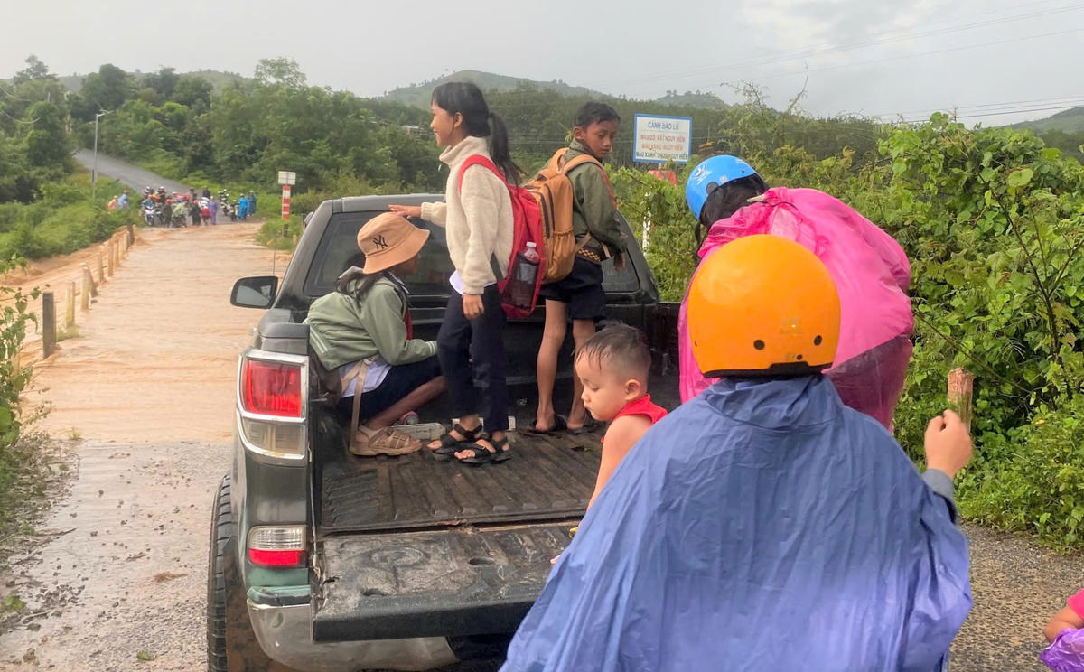 Chị Y
Huen (mắc áo mưa) đang đưa con lên xe để qua cầu  Cầu tràn đoạn qua làng Khúc Na. Ảnh: NVCC.