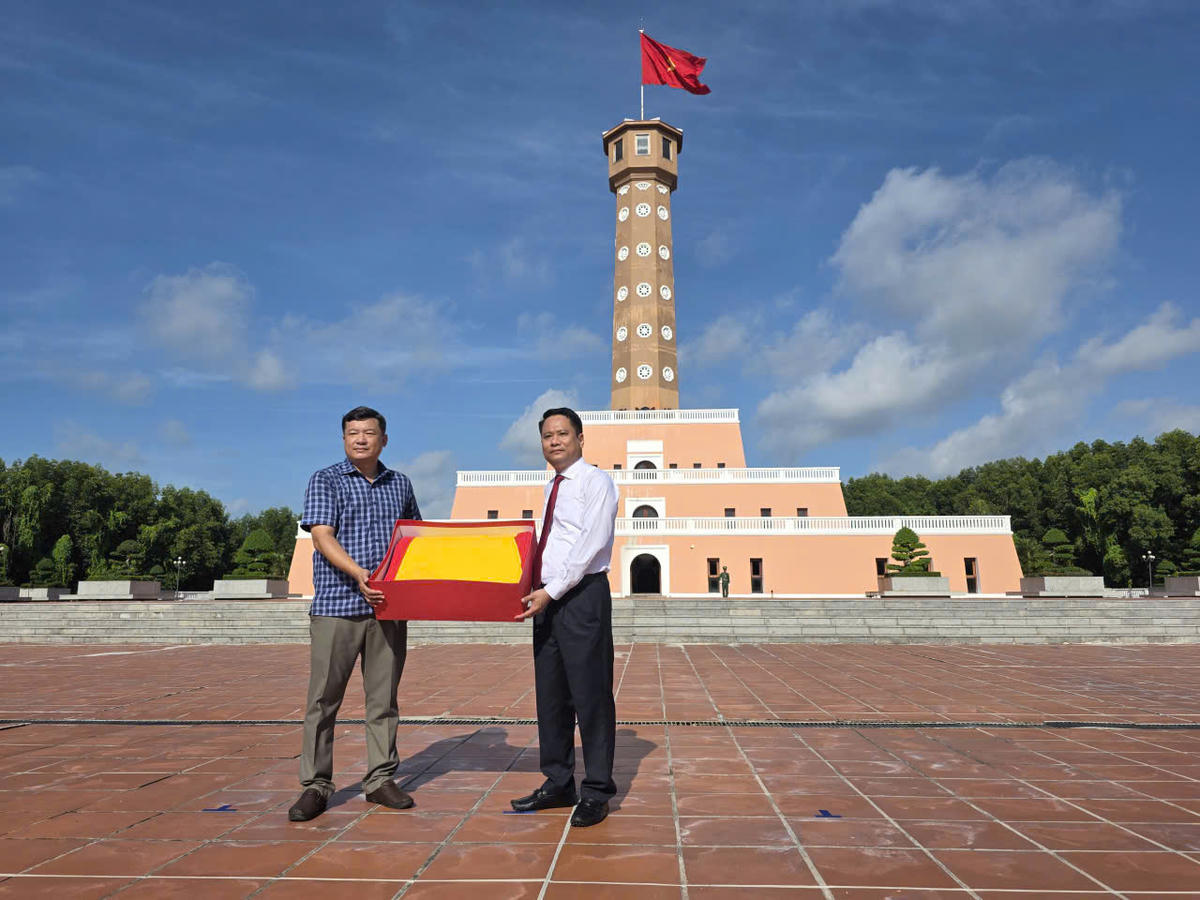 Nhà báo Trương Thành Trung - Tổng biên tập Báo Đại Đoàn Kết nhận cờ Tổ quốc của  Vườn Quốc Gia Mũi Cà Mau trao tặng.
