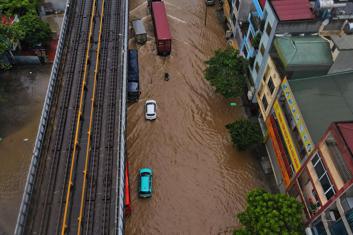 Do sát vỉa hè bị ngập sâu, nhiều ô tô phải di chuyển vào khu vực gần dải phân cách khiến giao thông hỗn loạn.