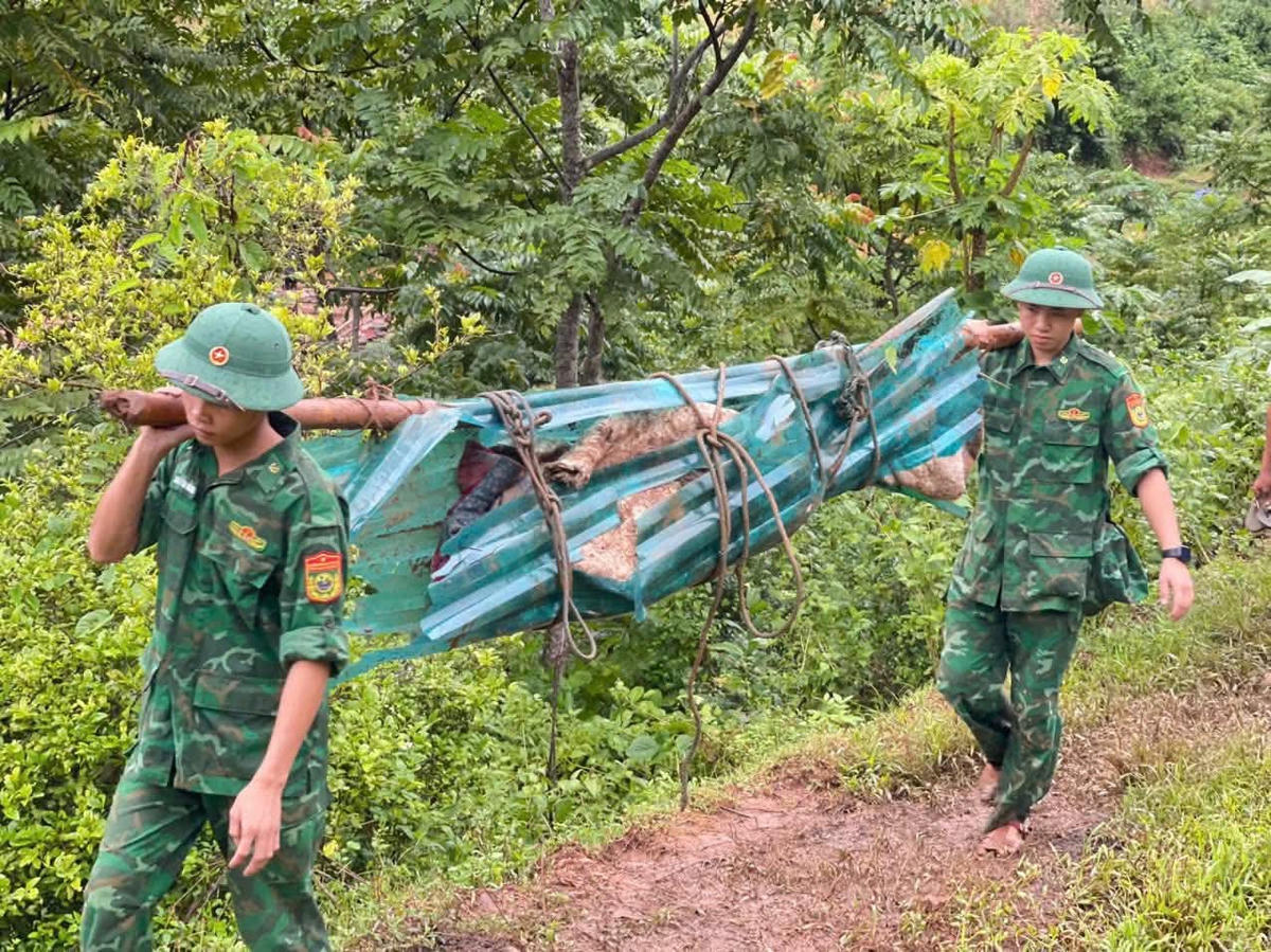 Cán bộ ĐBPCK Tén Tằn hỗ trợ đưa người thiệt mạng đi an táng sáng 7/10. Ảnh: Liên Lưu.