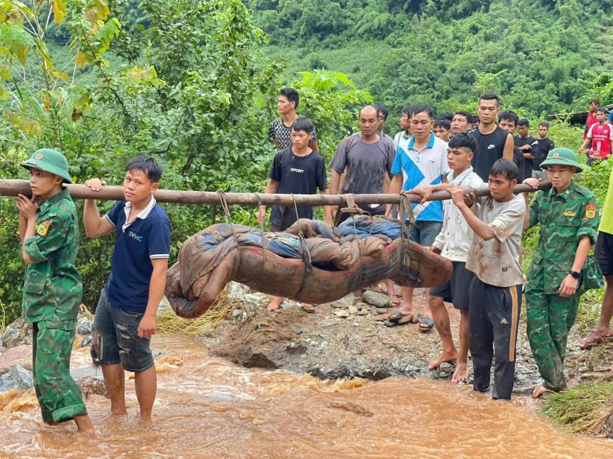 Lực lượng chức năng đưa thi thể 2 vợ chồng ở bản Đoàn Kết đi an táng. Ảnh: Liên Lưu.