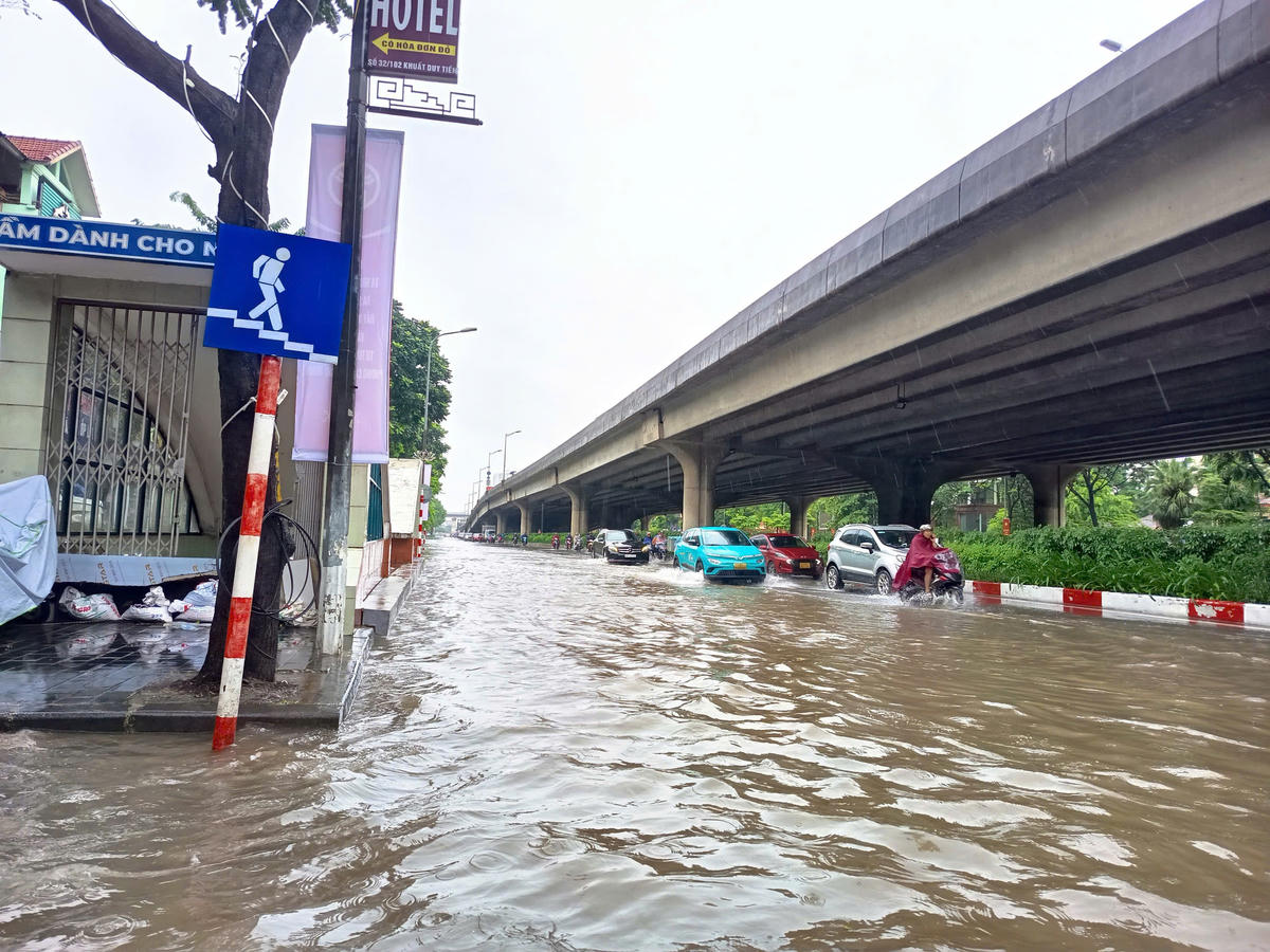 Nước mênh mông, các phương tiện phải tìm lối đi sát mép đường.