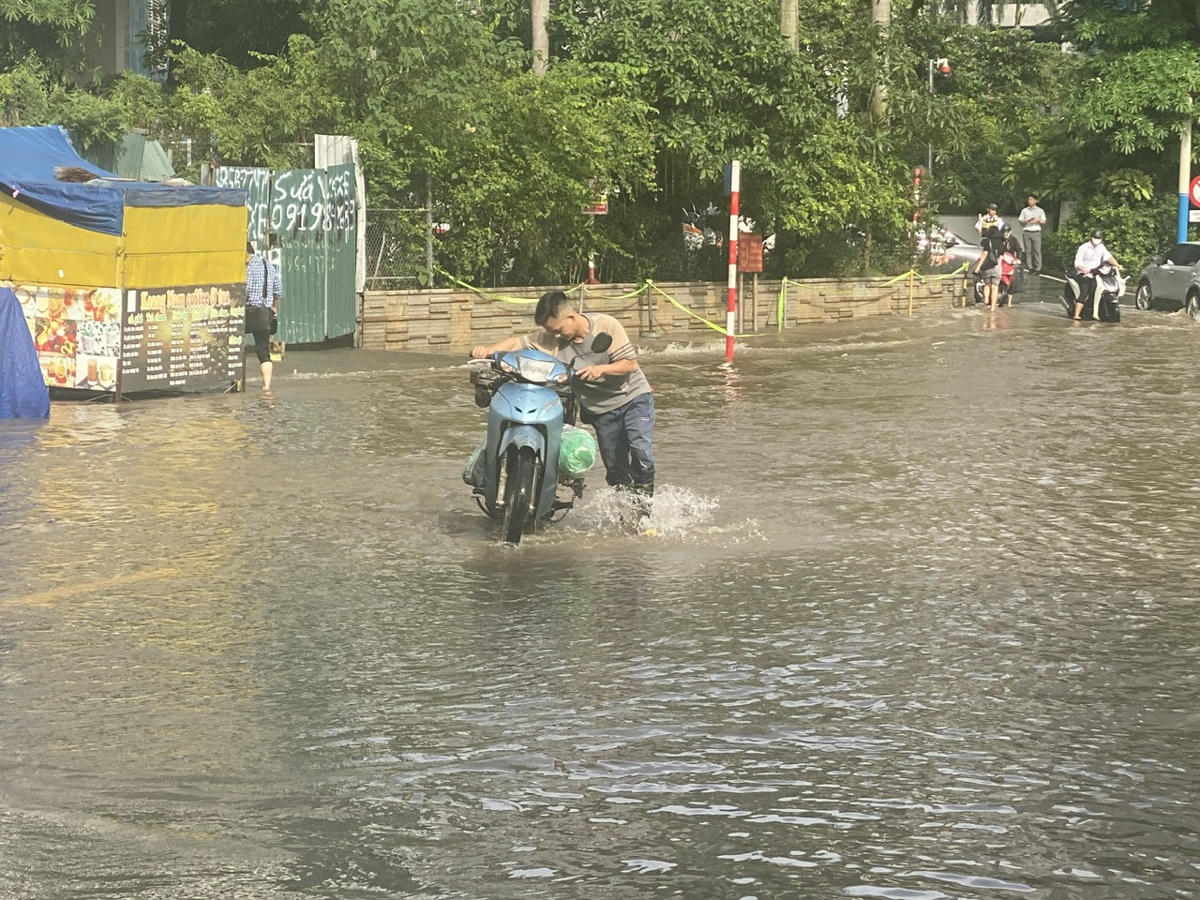 Người dân phải dắt xe lội nước trên phố Nguyễn Quốc Trị.