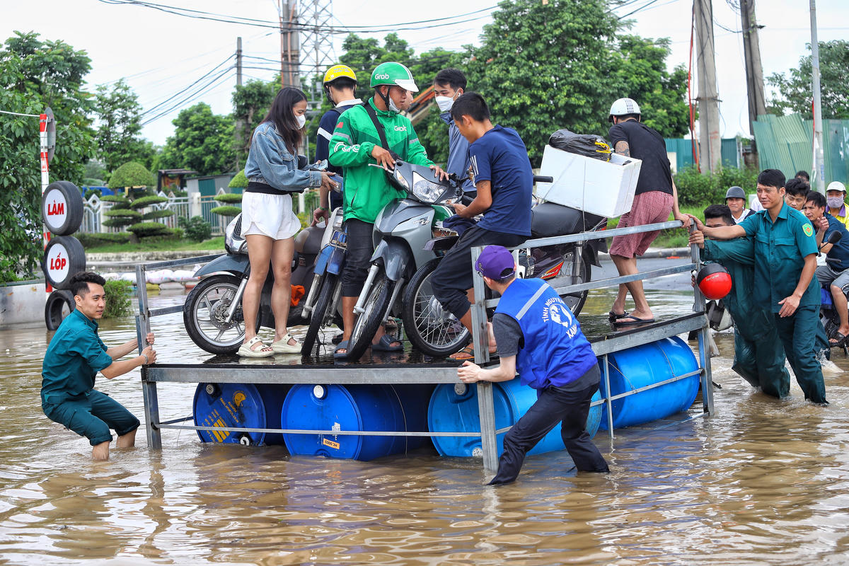 Dân quân tự vệ, cố gắng kéo phà đưa người dân qua vùng nước sâu.