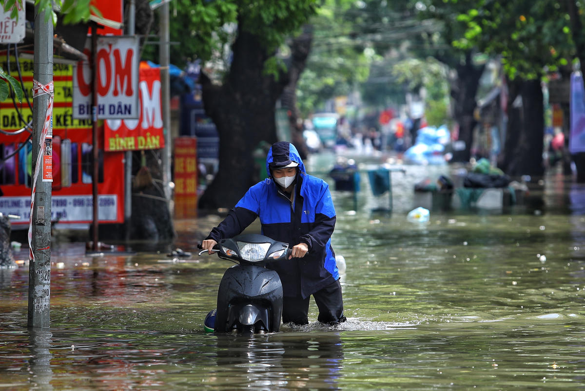 Người dân vất vả vượt qua ngập úng tại phường Tây Mỗ (Hà Nội).