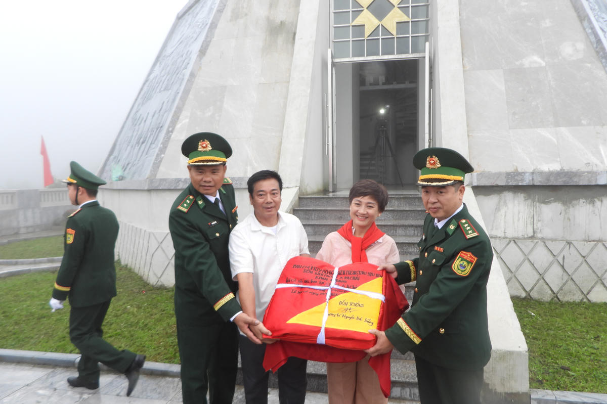 Báo Đại đoàn kết và đơn vị đồng hành trao tặng Đồn Biên phòng A Pa Chải lá Quốc kỳ tại Cột cờ A Pa Chải. Ảnh: Đ.S.