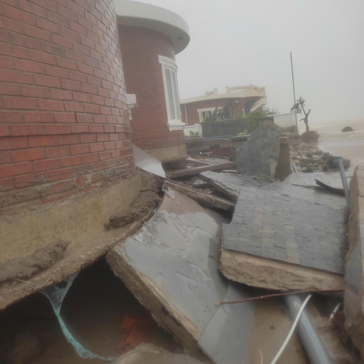 Phần móng nền của một căn villa bị sóng khoét sâu hở hàm ếch, lộ ra phần móng nông. Theo chủ một căn villa, nếu có hệ thống bờ kè kiên cố bảo vệ, thiệt hại do bão số 10 gây ra cho khu biệt thự sẽ không đến mức nghiêm trọng như vậy. Ảnh: Người dân cung cấp