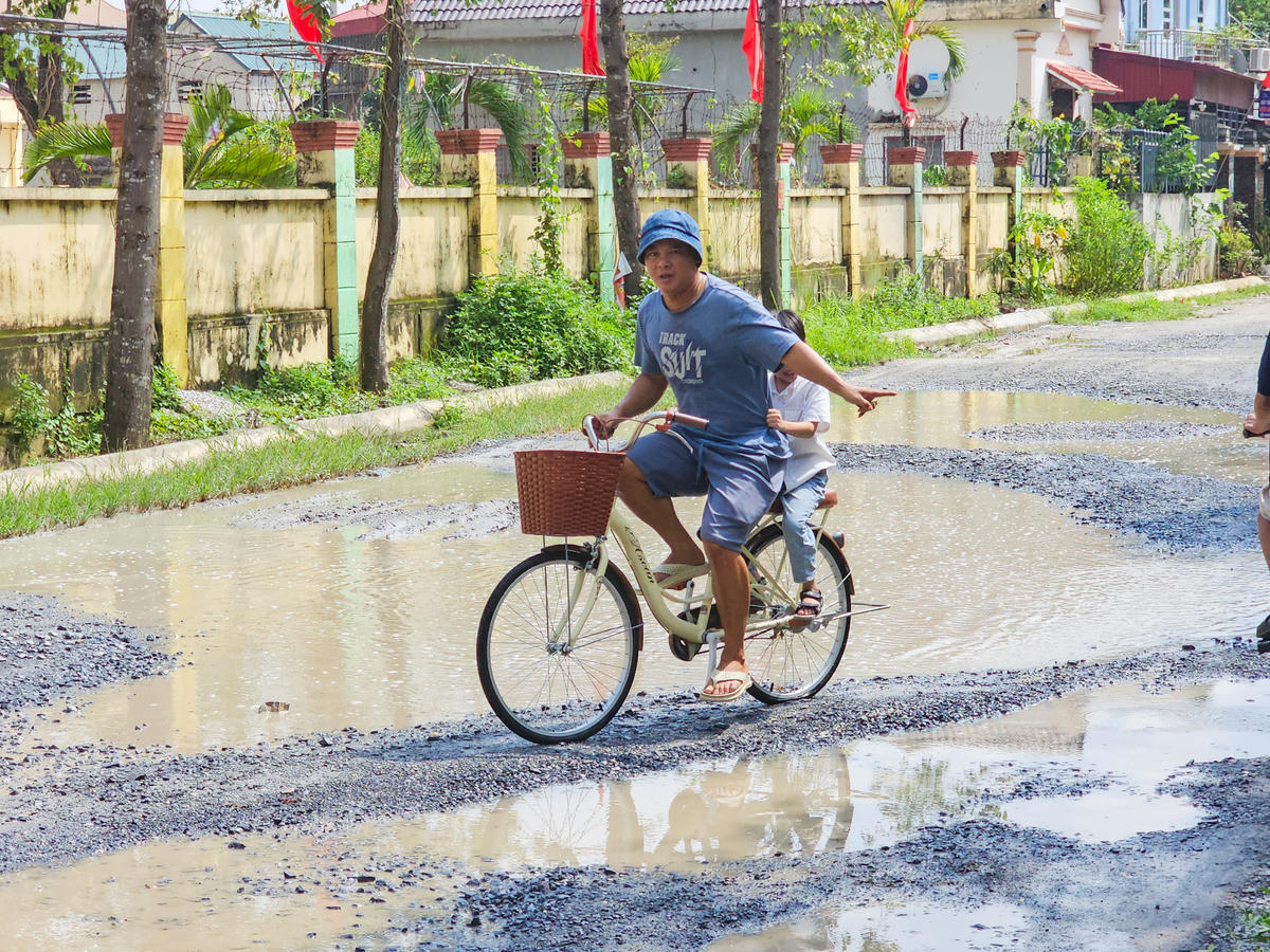 Những vũng nước trên mặt đường khiến người tham gia giao thông phải cố gắng giữ thăng bằng. Ảnh: Đình Minh
