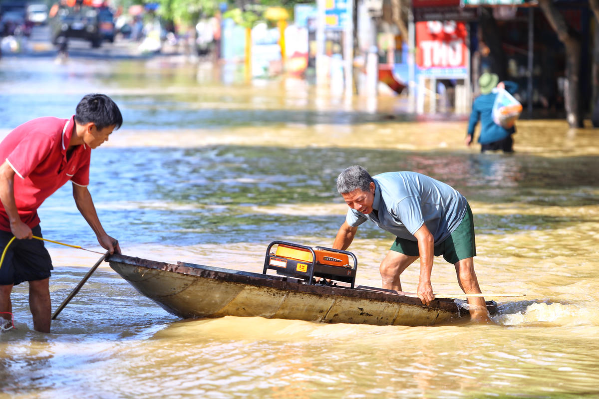 Người dân lái thuyền ra khỏi vùng ngập.