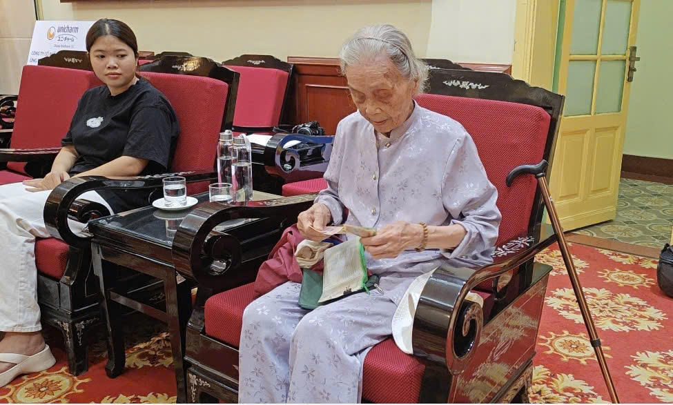 Cụ Hoàng Thị Tường Vinh cẩn thận chuẩn bị số tiền tiết kiệm của mình để gửi đến đồng bào vùng lũ. Ảnh: Văn Hoa