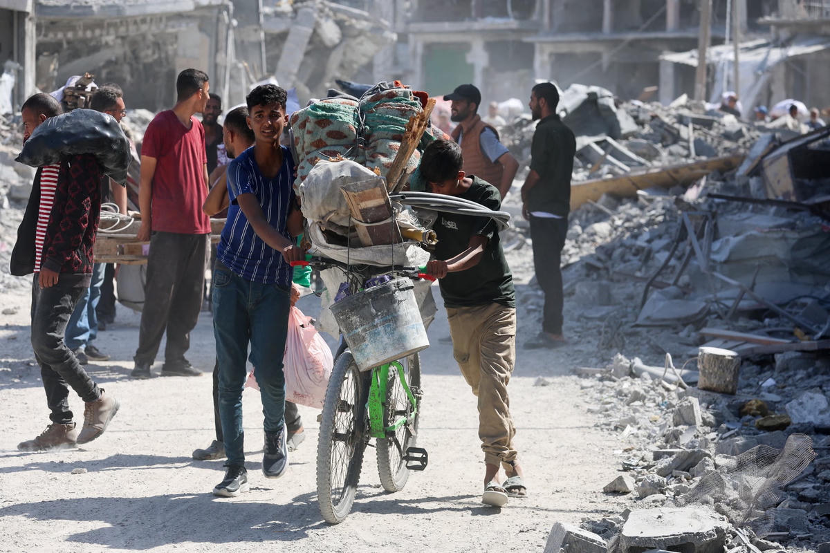 Người dân Gaza thu dọn đồ đạc trở về Gaza City. Nguồn: Reuters.