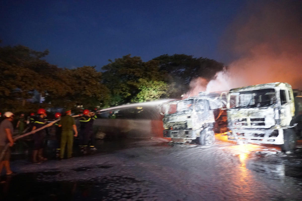 Lực lượng chức năng đang nổ lực dập lửa bãi xe phía sau cửa hàng xăng dầu. Ảnh: Nguyễn Tín