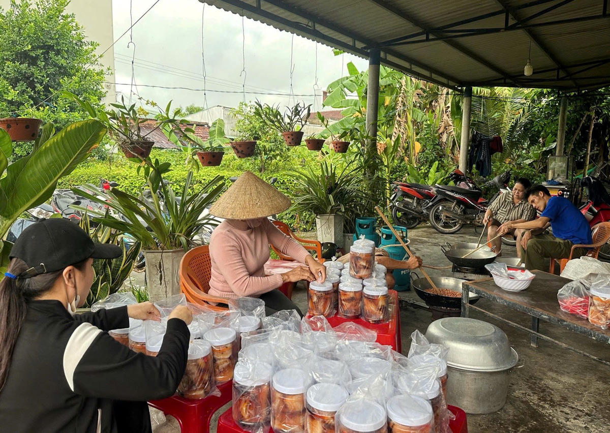 Người dân xã Đồng Dương đang đóng hộp những món ăn ngon gửi về đồng bào vùng lũ.  Ảnh: CV.