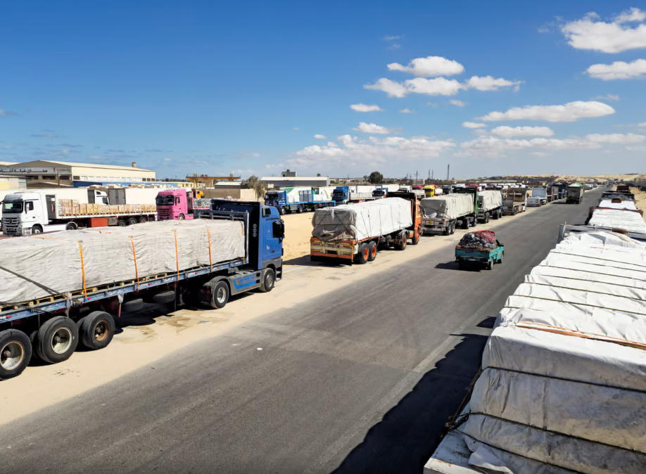 Xe tải chở hàng viện trợ nhân đạo xếp hàng chuẩn bị vào cửa khẩu Rafah ở Ai Cập. Nguồn: The Guardian.