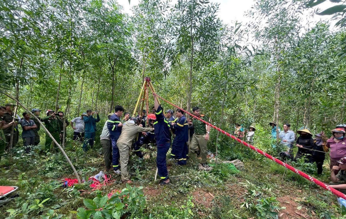 Lực lượng chức năng giải cứu ông P.V.H. rơi xuống giếng hoang. Ảnh: Công an cung cấp.