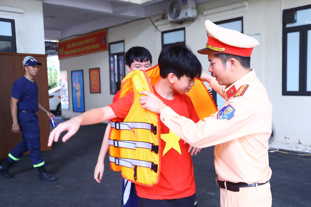 Đội Cảnh sát đường thủy số 2 hướng dẫn các em học sinh mặc áo phao đúng cách.